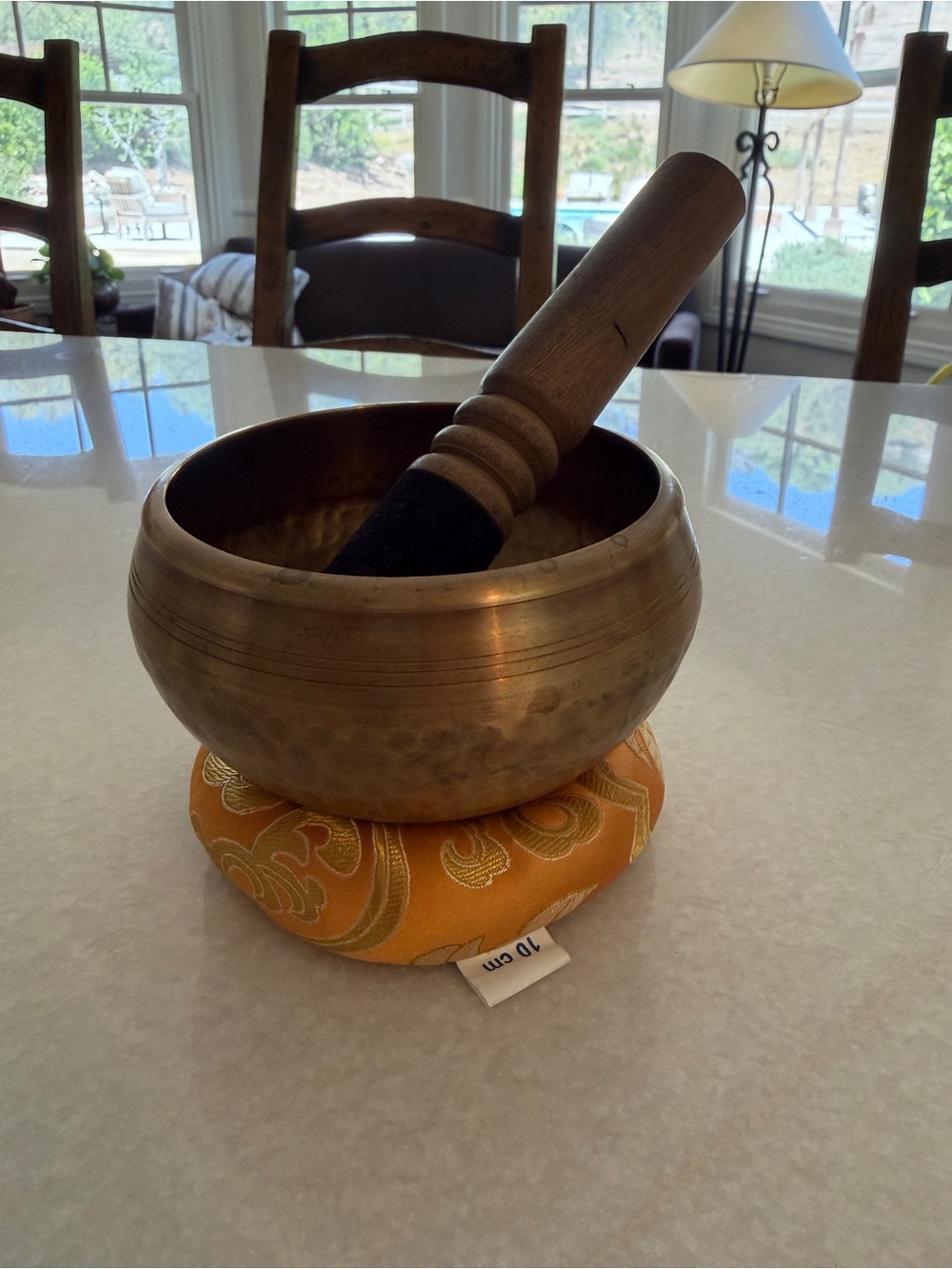 Vintage Brass Singing Bowl with Wooden Mallet on Gold-Patterned Cushion
